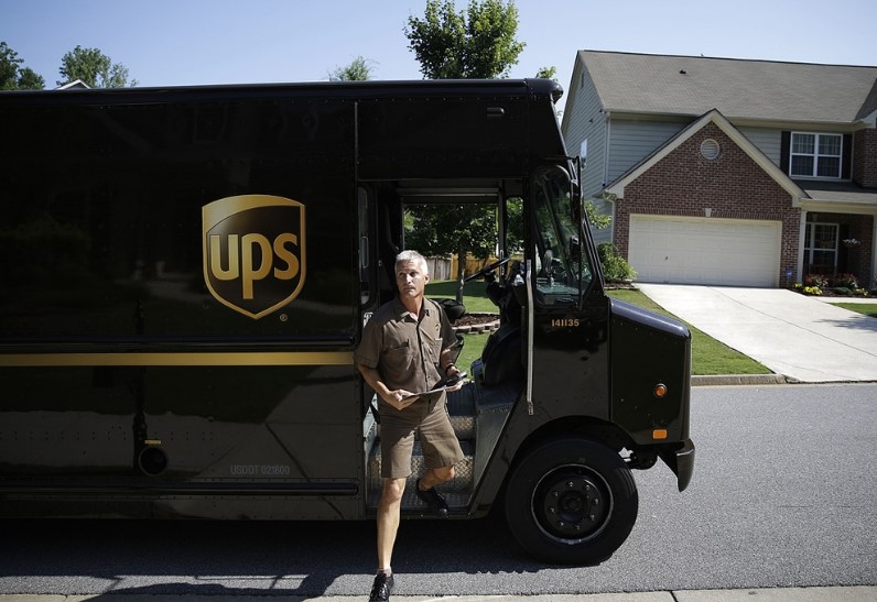 A UPS delivery man getting off the UPS delivery van